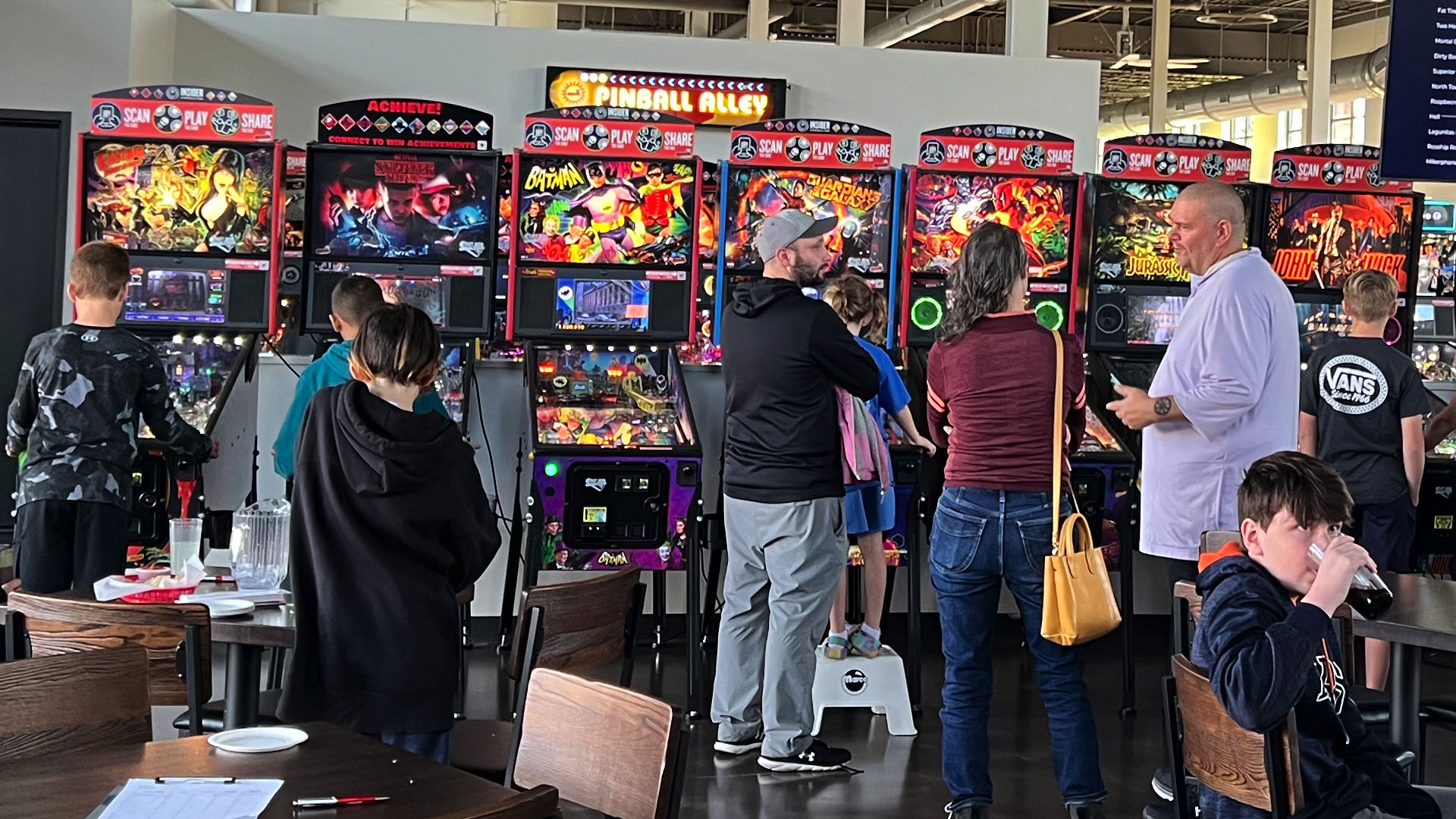 Kids and adults enjoying pinball