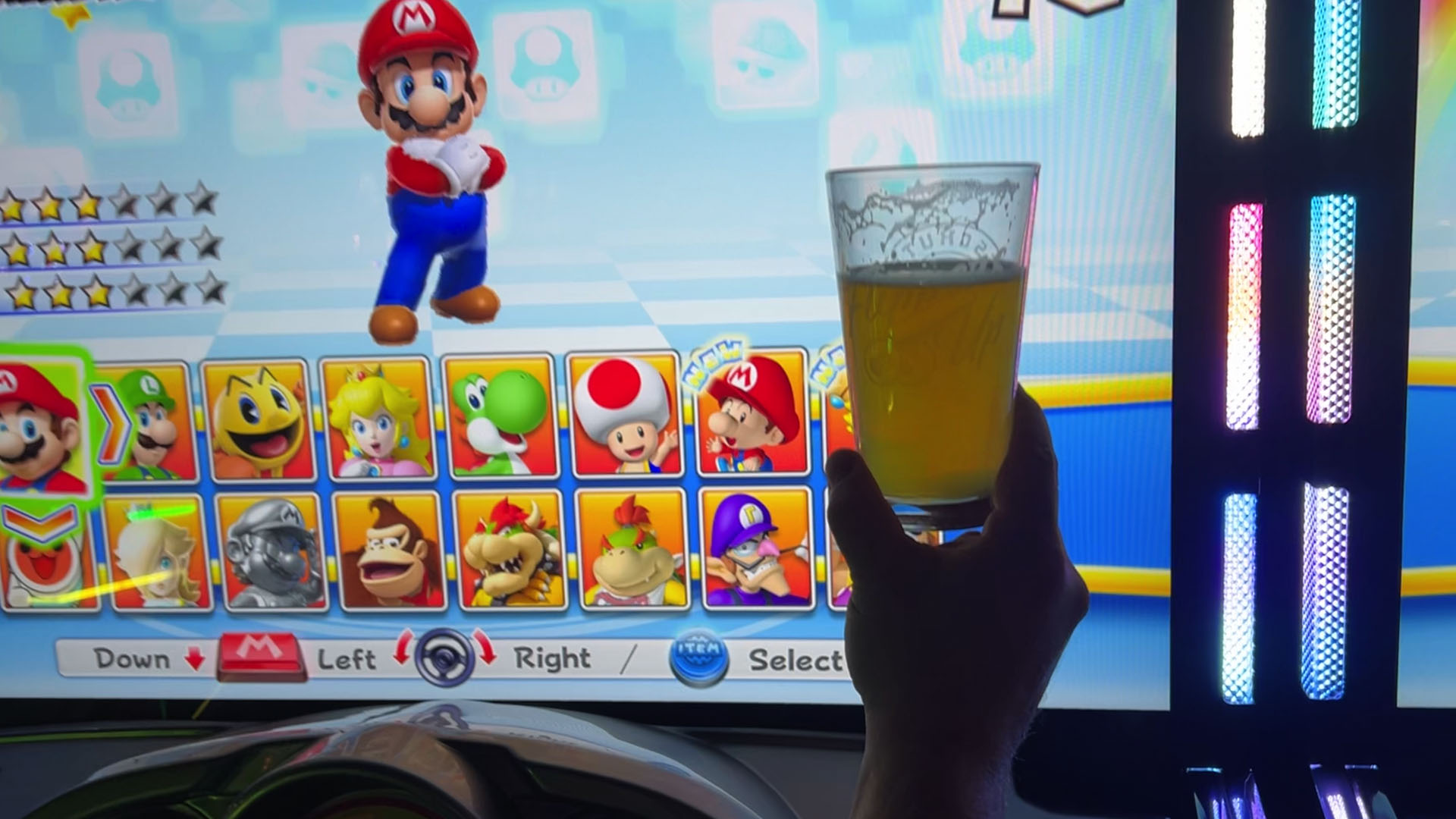 A beer being held up in front of the Mario Kart select racer screen