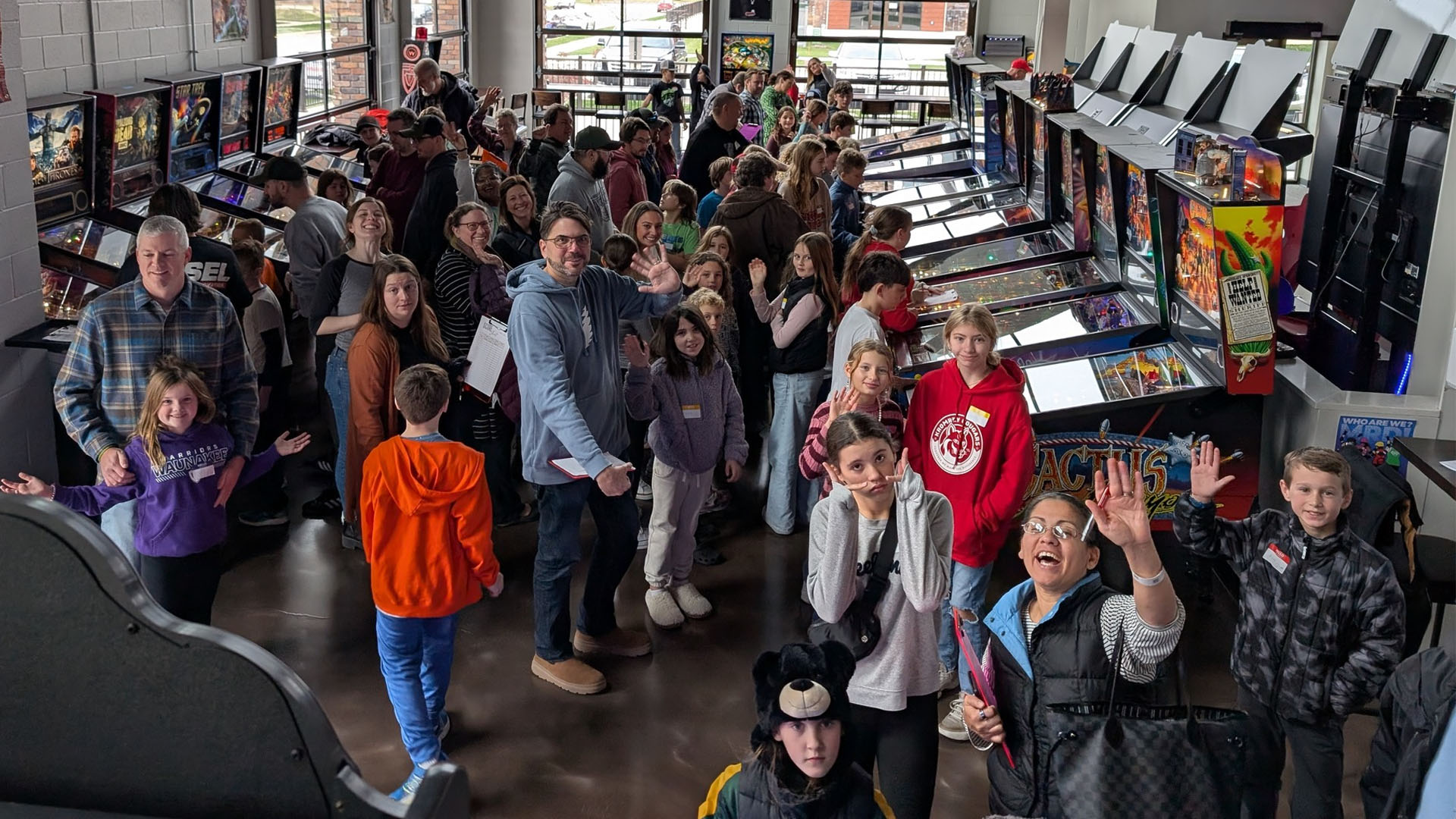 Youth pinball group waving at the camera