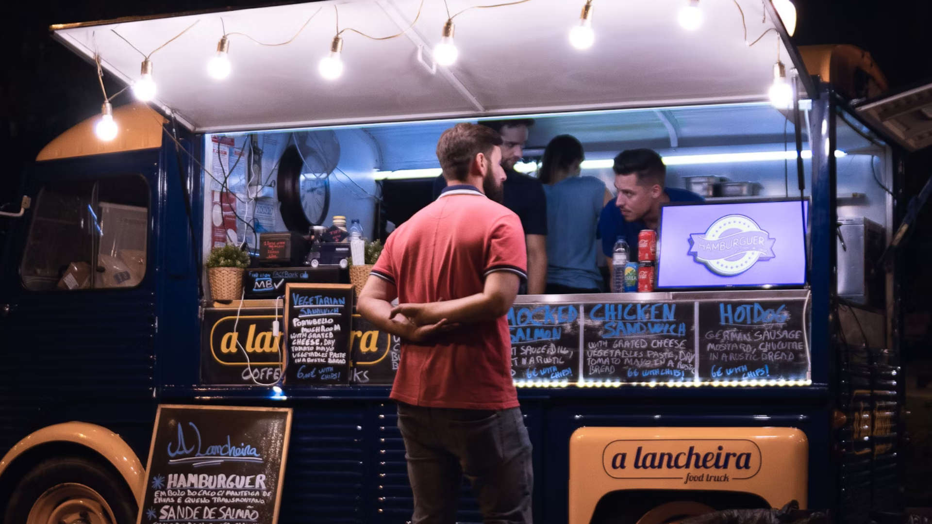 Someone ordering food at a food truck at night