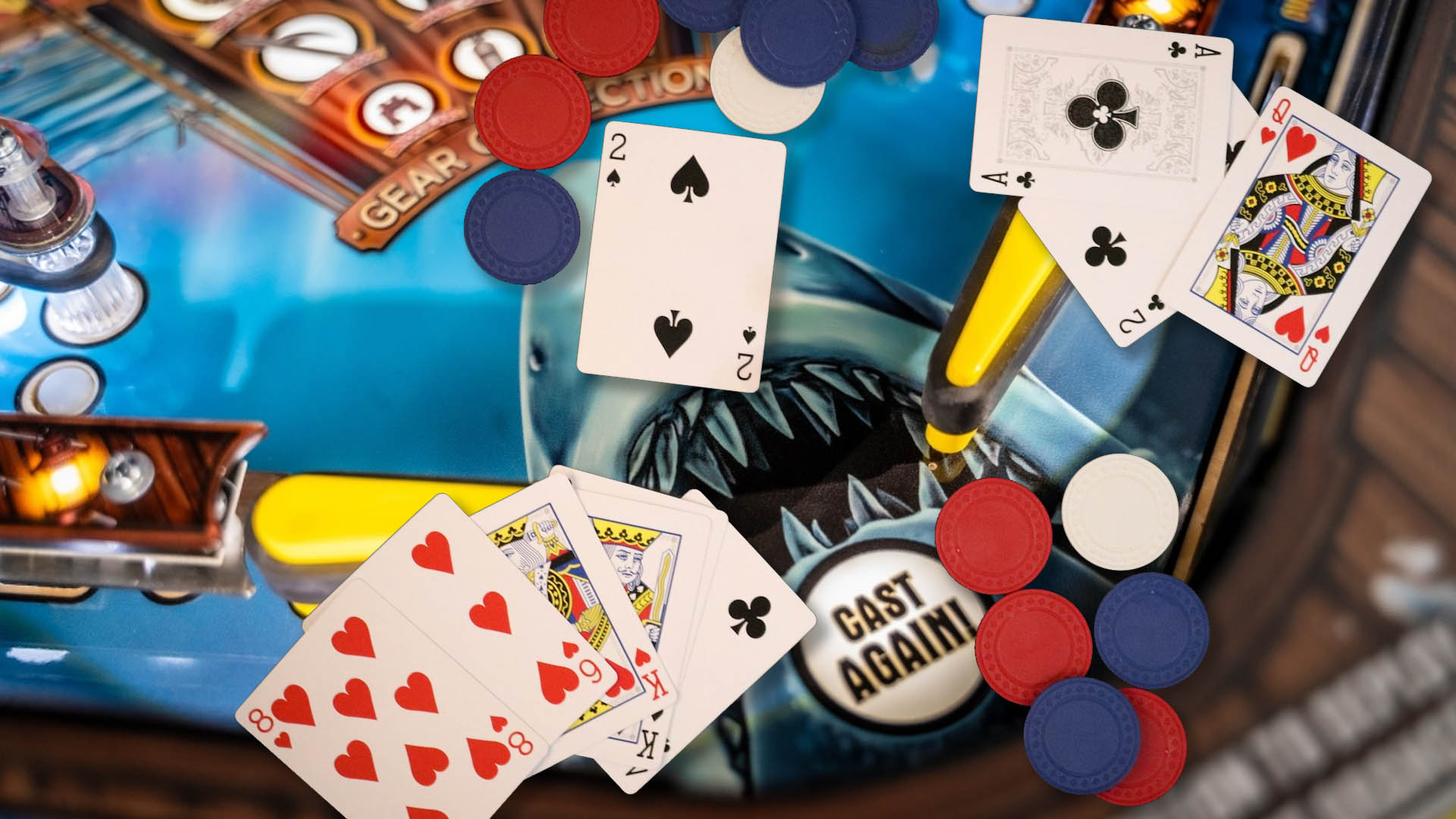 Poker chips and cards on top of Jaws Pinball