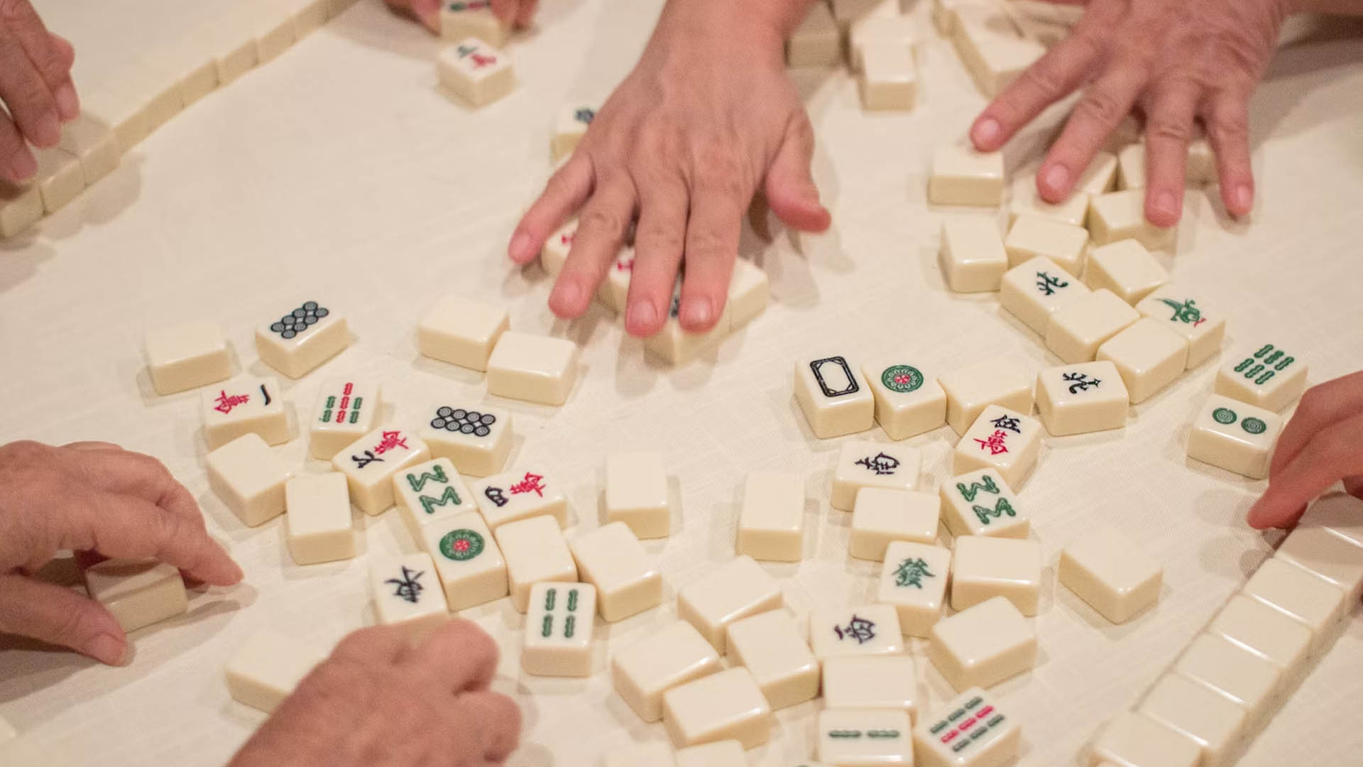 A group of people playing Mahjong
