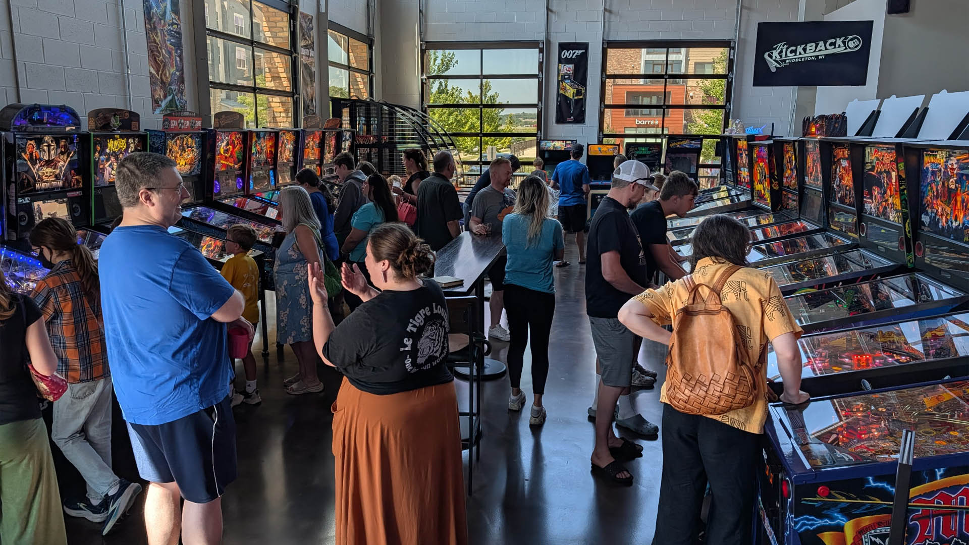 A large group of kids playing pinball